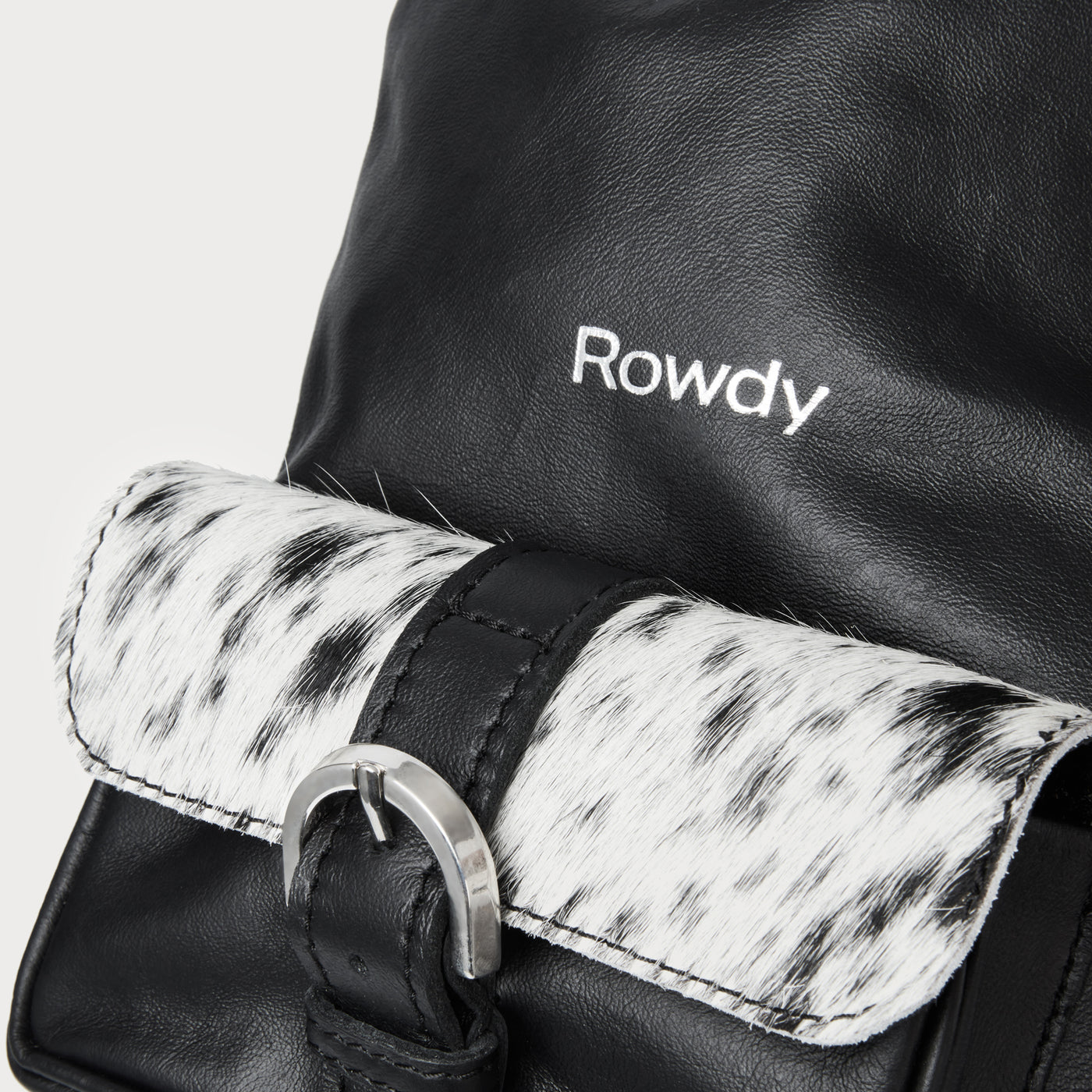Hair-on-hide flap. Hidden back pocket.