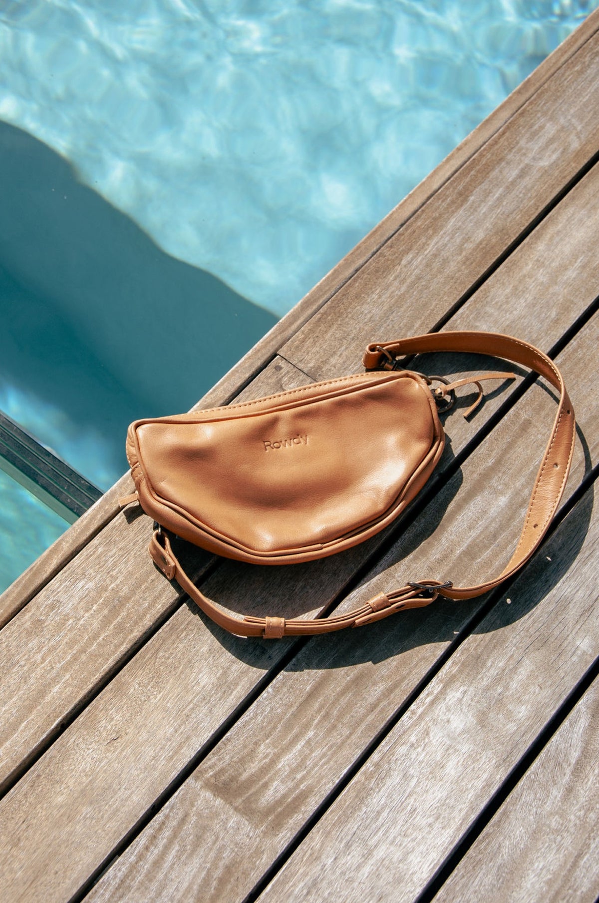 Tan leather Rowdy Moon Bag by the pool
