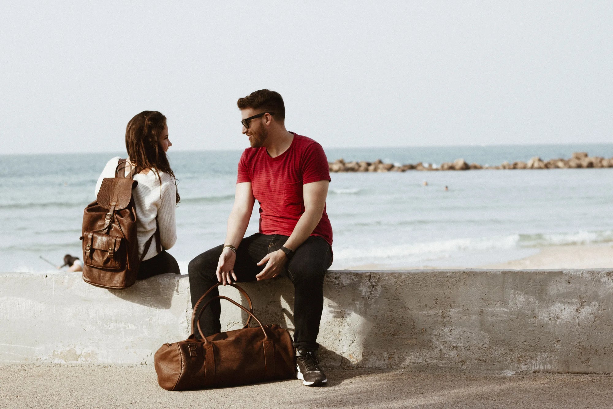 Couple by the sea with a Rowdy leather rucksack and duffel bag